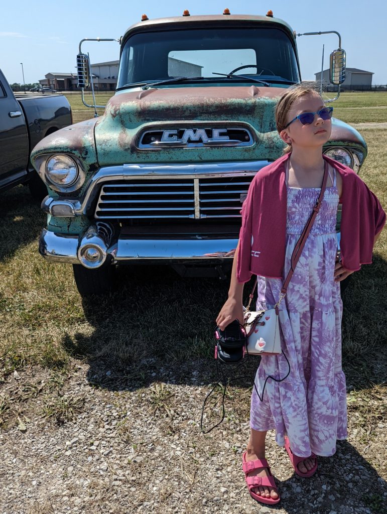 photo of Ada standing in front of a vintage GMC pickup truck at Iowa Speedway