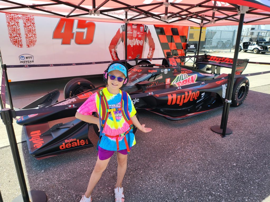 photo of Ada standing in front of Hy-Vee IndyCar