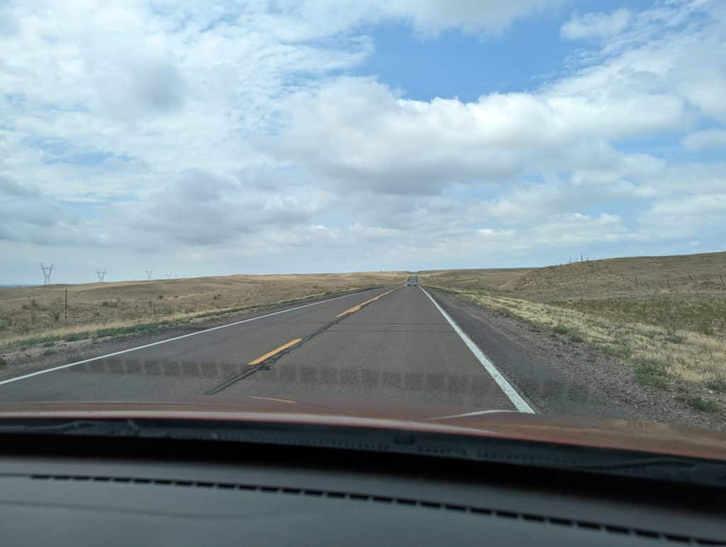 photo taken out windshield of car on I80 that shows flat prairie and highway