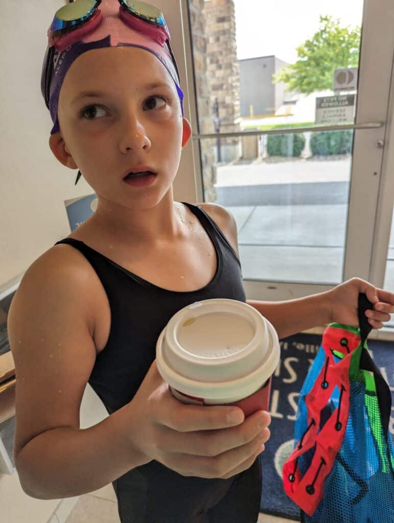 photo of child holding a disposable coffee cup