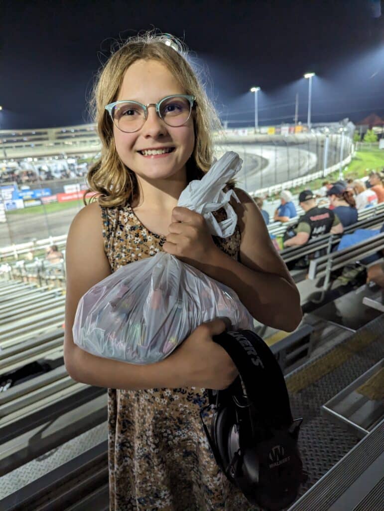 photo of child holding a bag of candy in the grandstands at Knoxville Raceway